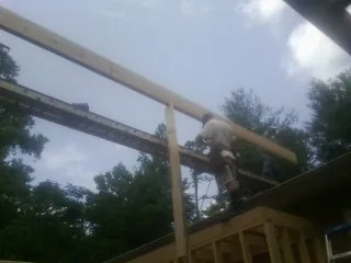 Carpenter setting a ridge beam over a new addition frame — Ice Dam Removal by Roofing Brothers in Macksburg