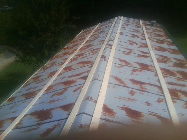 Rusted metal roof panels with new wood purlins before replacement — Storm Damage Roof Repair in Macksburg by Roofing Brothers