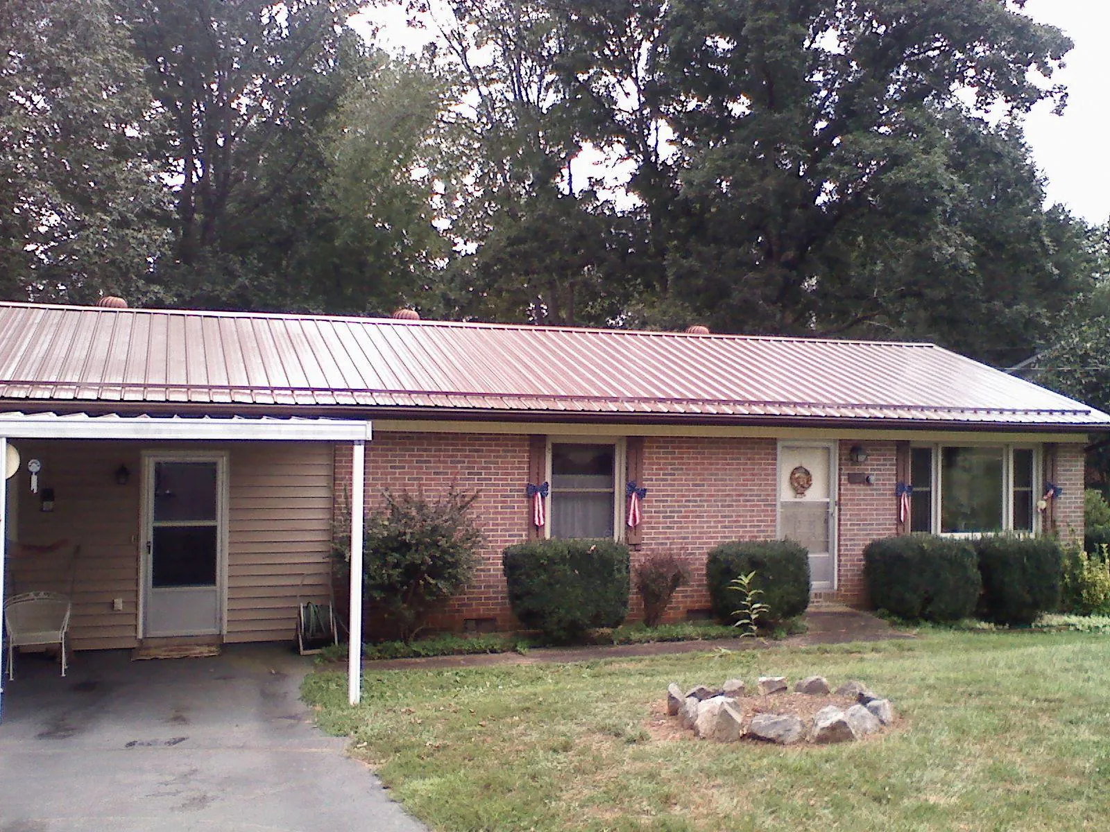 Bronze metal roof and carport on a brick ranch home — Roof Repair work by our crew in Macksburg