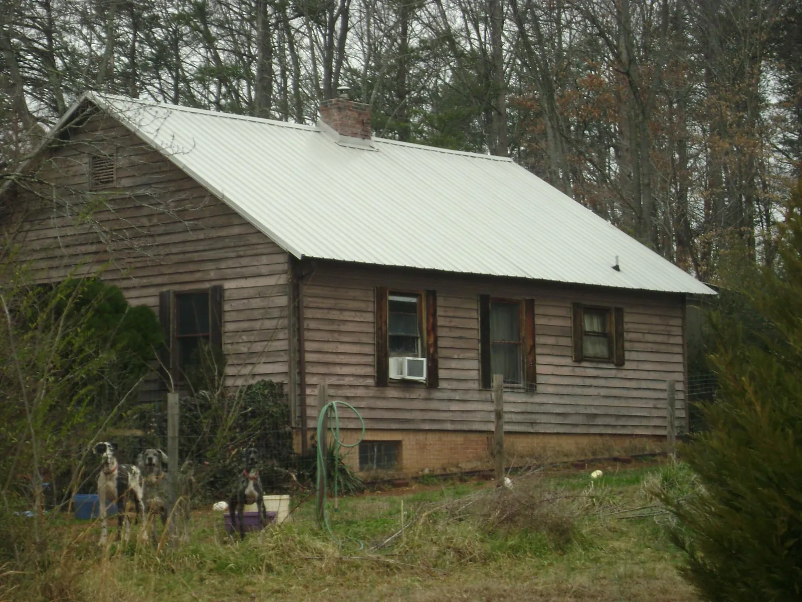 White metal roof on an old wood sided farmhouse, from a Metal Roof Installation job in Macksburg